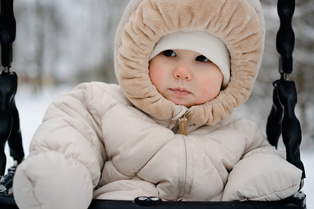 istock Curious baby experiencing winter fun on snowy swing 2254521596