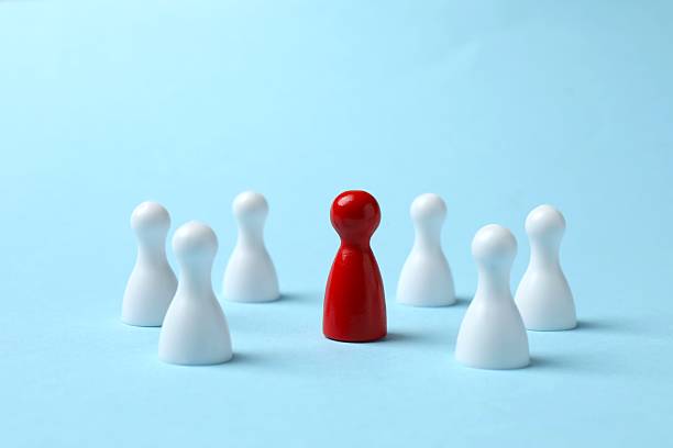 istock Group of colored pawns on the table. Concept of unity 2254523703