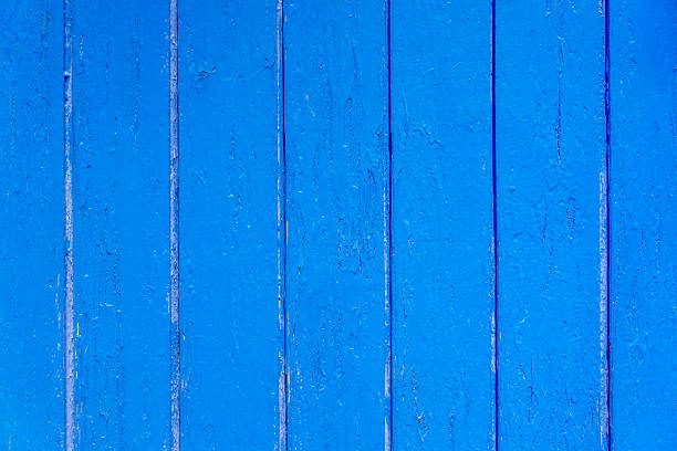 Close up of a traditional wooden fence, painted bright blue.