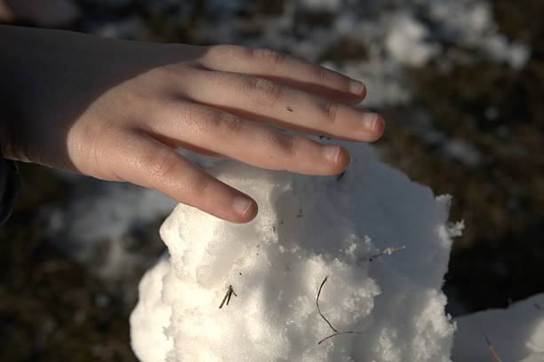 Child hand holding snow symbolizing digital detox and offline outdoor play during winter. Healthy childhood, mindfulness and balanced lifestyle concept.