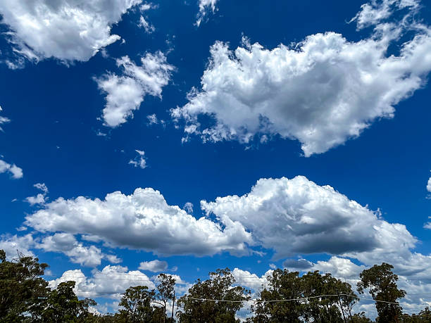 Wispy cirrus clouds and patchy altocumulus formations scatter across the sky, creating a layered texture above a rugged mountain range.