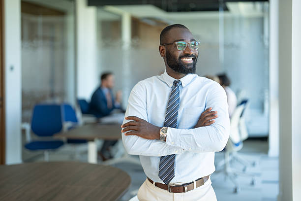 istock Confident businessman smiling with folded arms in modern office 2254531843