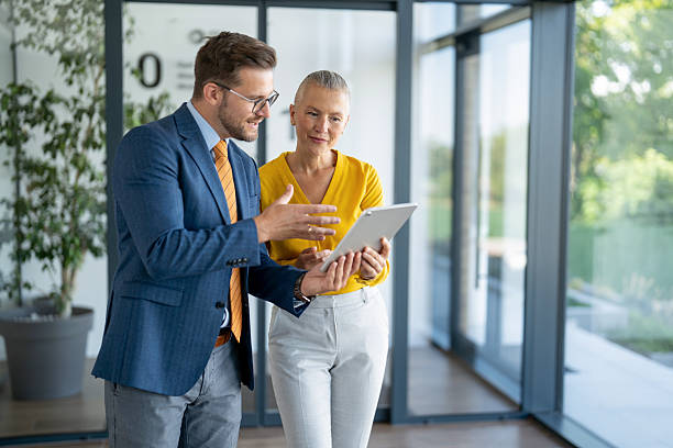istock Business colleagues using digital tablet, discussing work in modern office 2254531877