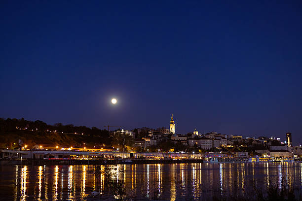 istock Nighttime Cityscape with Moon Reflecting on River 2254532198