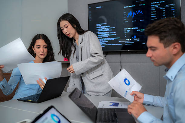 istock Diverse business team in a meeting room analyzing a report and data chart on a laptop. Professional colleagues brainstorming a successful strategy and solution for their new business startup. 2254537437