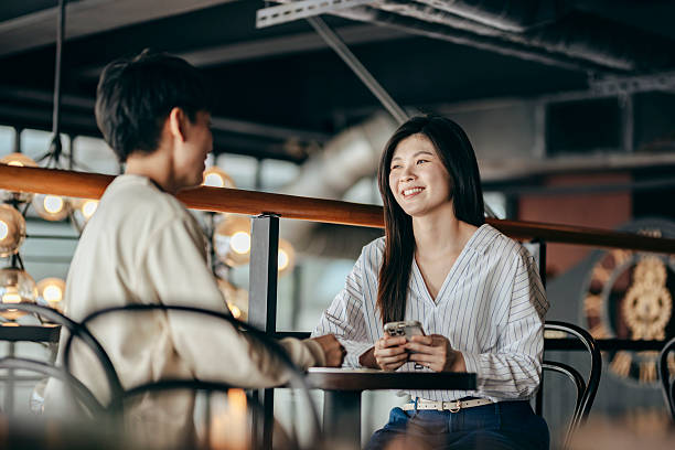 istock Two Asian women having a serious and engaging conversation in a modern cafe. 2254537785
