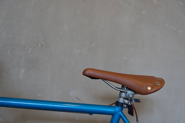 Close-up of a brown leather bicycle saddle featuring, mounted on a bicycle frame against, highlighting the vintage and comfortable design of the seat