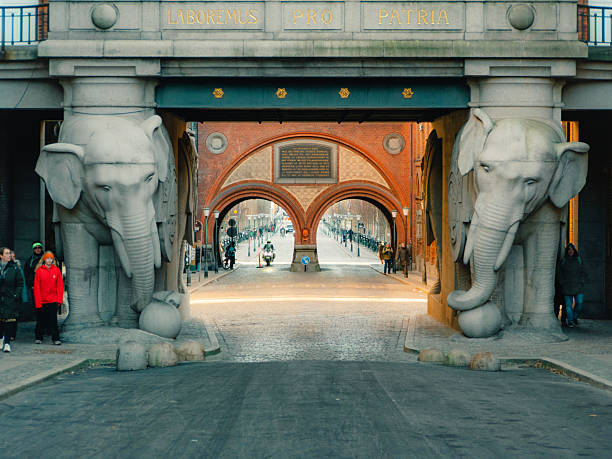 Copenhagen, Denmark – December 28, 2025: Historic Elephant Gate and Dipylon arch at the Old Carlsberg Brewery site featuring granite elephant statues and ornate brick architecture.