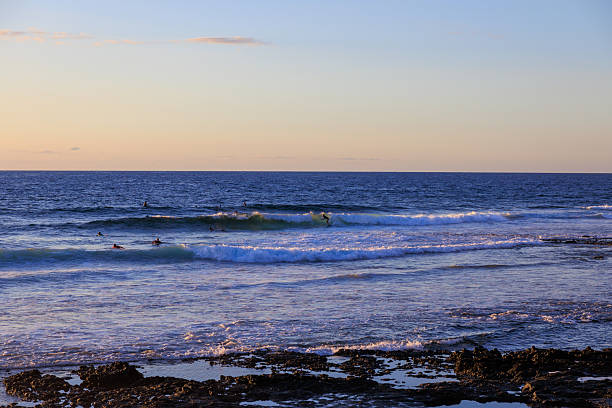 istock Surfers practising surfing on surfboards and Atlantic Ocean panorama during sunset in holiday resort Playa de las Americas on Canary Island Tenerife, Spain 2254552852