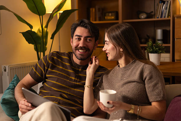istock Couple relaxing on sofa at home with tablet 2254557068