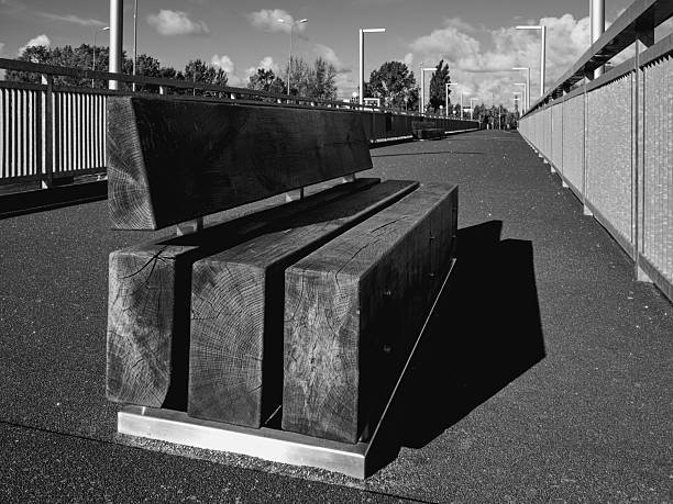 Minimalist urban design, empty public space, perspective lines, geometry, and contrast. Concept of solitude, city infrastructure, street furniture, and contemporary architecture.