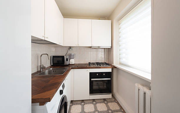 istock Modern Home Compact Kitchen Interior with Wooden Counters and White Cabinets 2254561301