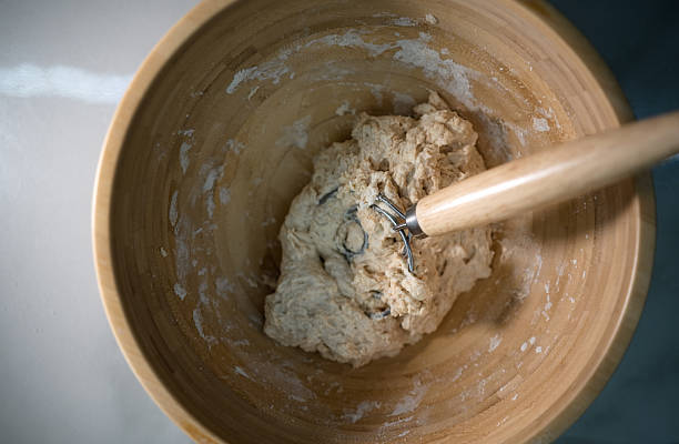 Mixing dough in a wooden bowl
