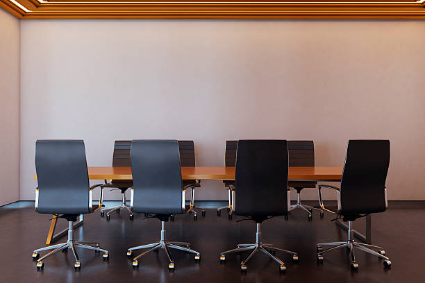 Interior of corporate meeting room with empty office chairs around wooden desk, modern design, minimal wall and ceiling, 3D Rendering