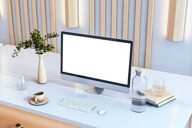 Minimalist office desk with computer screen mockup, keyboard, coffee cup, books and vase decor on white surface in modern workspace. 3D Rendering