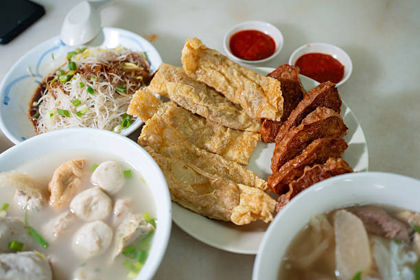 Deep fried beancurd with meat served with dipping sauces, alongside dry noodles and Yong Tau Foo soup.