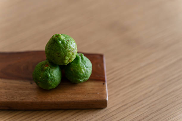 Fresh bergamot limes placed on wooden board.