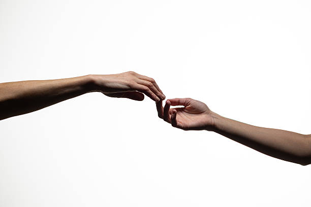 istock Two human hands reaching out and almost touching against a plain white background, symbolizing longing, connection, or separation. Includes copy space 2254572108