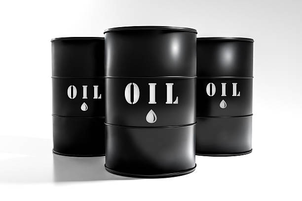 Three black oil barrels isolated on a clean white background. Industrial petroleum storage concept representing crude oil, fossil fuels, energy industry, oil prices, global energy supply, and environmental impact.