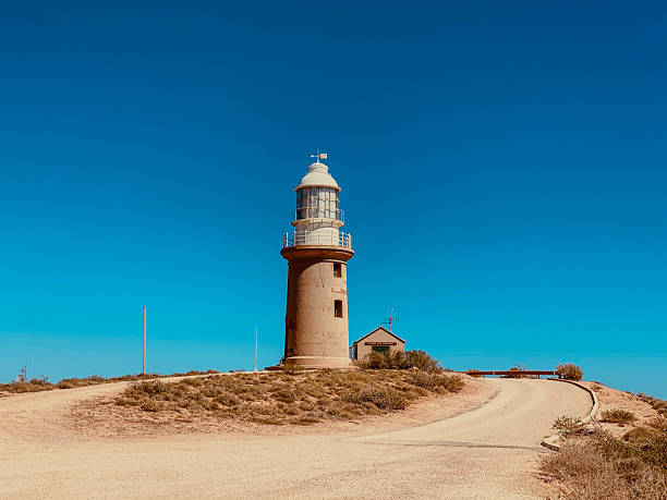 istock Lighthouse Tower Standing Tall Under Clear Blue Sky, Guiding Light for Navigation 2254575064