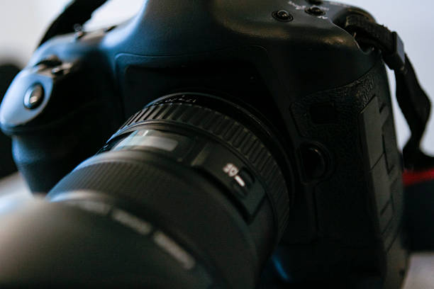 Macro close-up of professional DSLR camera body and lens with shallow depth of field