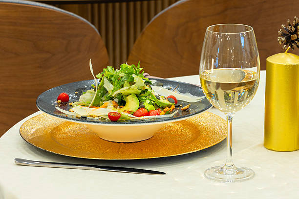 istock Green salad and wine served on table in restaurant 2254579013