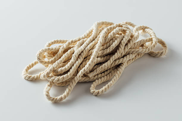 A well-crafted knot dangles from a rope, gently swaying in the breeze. Above, a bright blue sky creates a vivid contrast, highlighting the craftsmanship and precision of the knot.