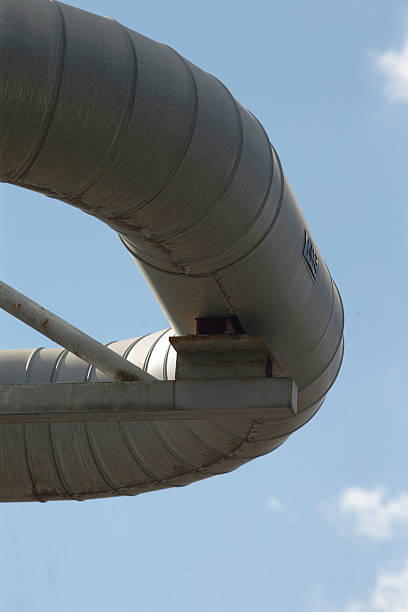 istock Industrial pipeline arc highlighted beneath expansive blue sky 2254580156