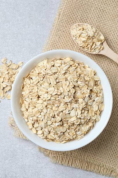 istock Composition with oatmeal flakes on gray background. Cooking breakfast 2254580885