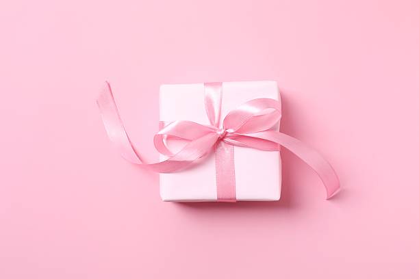istock Beautiful gift box with pink bow on color background 2254580988