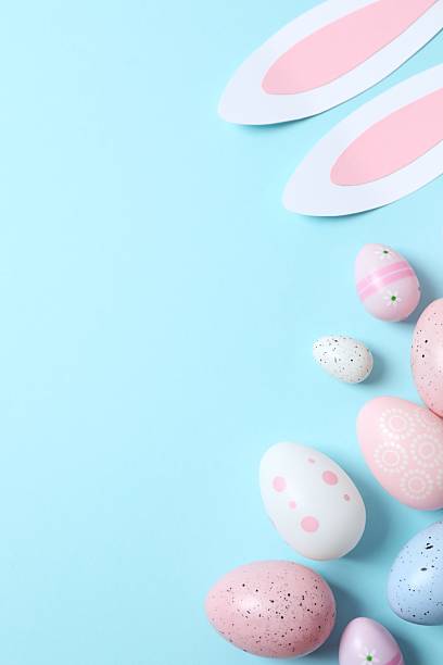 istock Happy Easter. Colorful eggs with bunny ears on blue background, space for text or advertising 2254581119