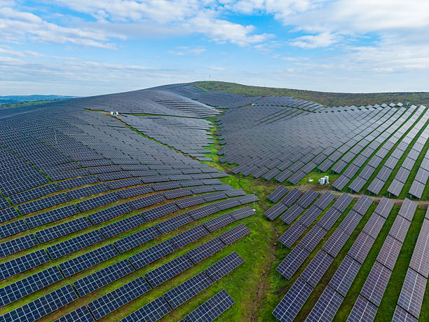 istock Solar panels cover a large area on rolling hills under a clear sky during the daytime in a renewable energy project 2254582499