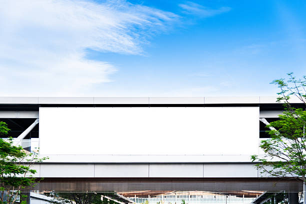 Large blank billboard on a city building against blue sky