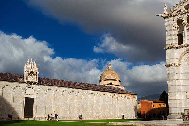 Pisa, Italy - October 24, 2025: Tourists visit the wonderful 'Piazza dei Miracoli' (Square of Miracles) with romanesque cathedral and monumental cemetery in Pisa