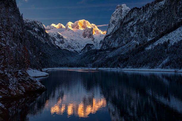 Spectacular winter view of lake Gosau, Gosausee with fresh snow on majestic mountains, pines. With the Dachstein mountain in the background