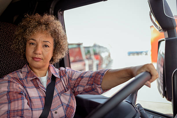 istock Female Truck Driver Looking at Camera Inside Truck Cab 2254585452