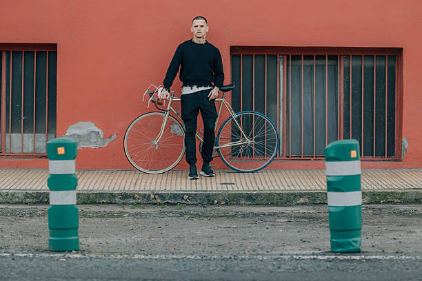 istock young man with bicycle on the street 2254586446