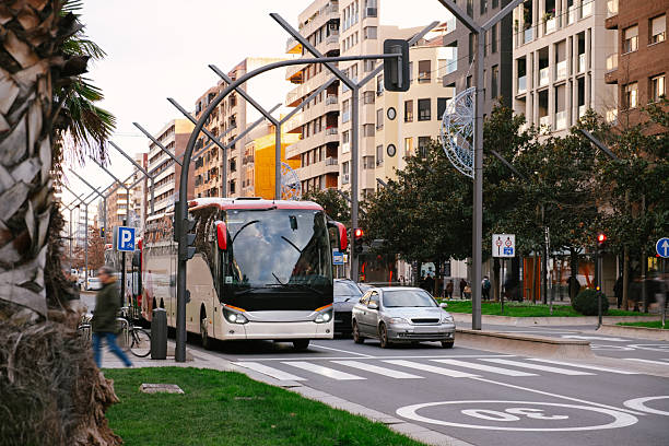 A coach bus in a city stopped in a pedestrian crossing