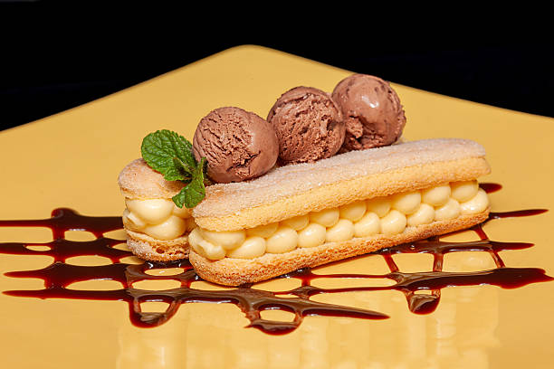 istock Eclair with chocolate ice cream and chocolate sauce on a yellow plate during dessert time 2254590319