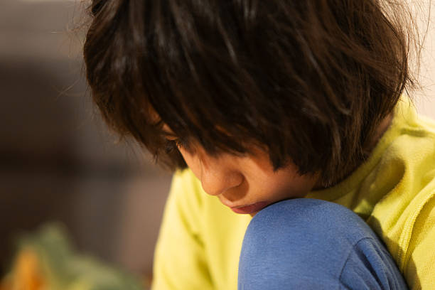 Young boy looking down, showcasing introspection, sadness, and solitude