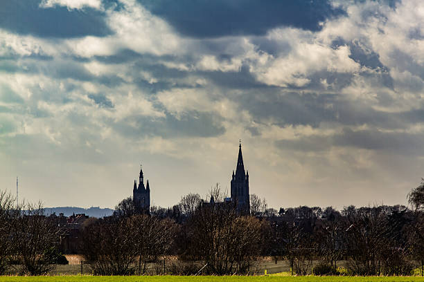 Skyline of Ypres, Belgium beneath a dramatic cloudy sky.