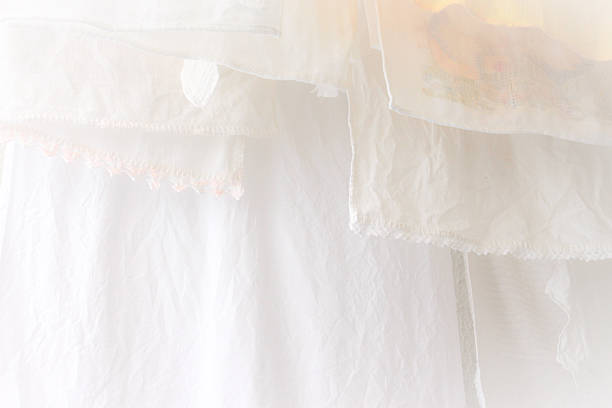 Many white clothes hanging on clothesline.