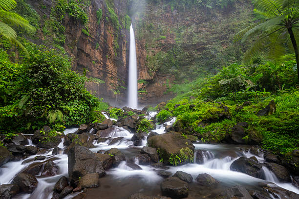 Kapas Biru Waterfall seen from below, surrounded by tropical vegetation, East Java, Indonesia