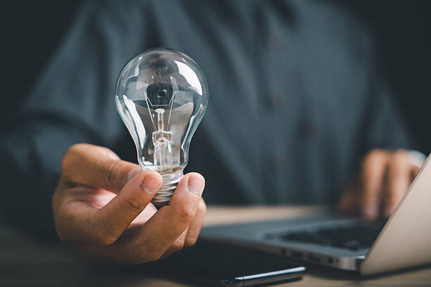 istock A person holds a light bulb in their hand, symbolizing an idea, while working on a laptop. 2254595565