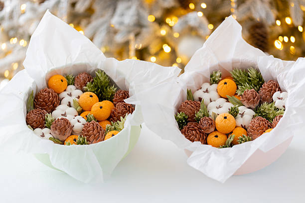 istock Zephyr arrangement featuring pine cones, cotton bolls, and oranges nestled in white tissue paper, creating a festive atmosphere with natural elements and seasonal charm 2254596250