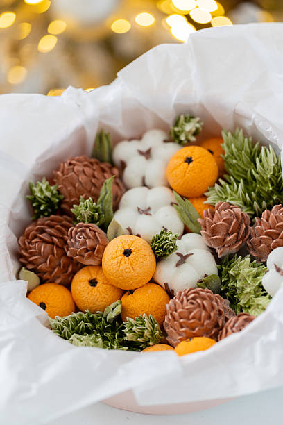 istock Zephyr arrangement featuring pine cones, cotton bolls, and oranges nestled in white tissue paper, creating a festive atmosphere with natural elements and seasonal charm 2254596253