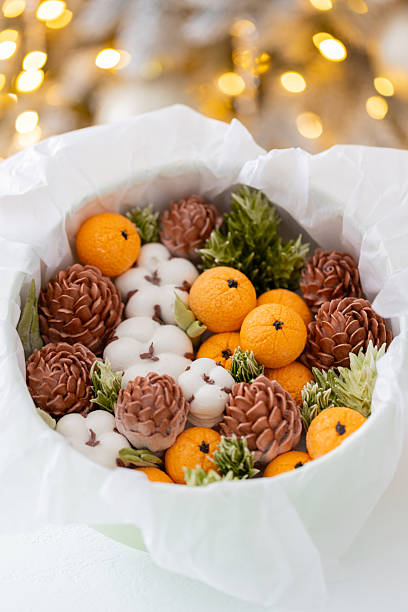 istock Zephyr arrangement featuring pine cones, cotton bolls, and oranges nestled in white tissue paper, creating a festive atmosphere with natural elements and seasonal charm 2254596257