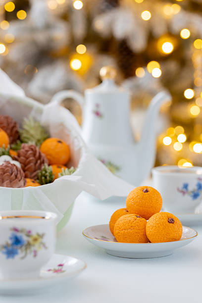 istock Zephyr Vibrant orange sweets arranged on a delicate plate beside a festive bowl filled with pinecones and greenery, creating a warm and inviting holiday atmosphere 2254596290