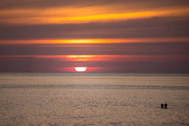 Image of the sun setting over the sea.
