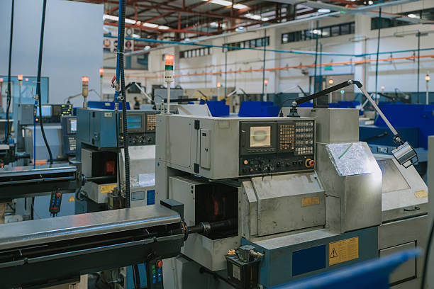 Close view of an automated CNC lathe machine and control panel inside a modern industrial production facility